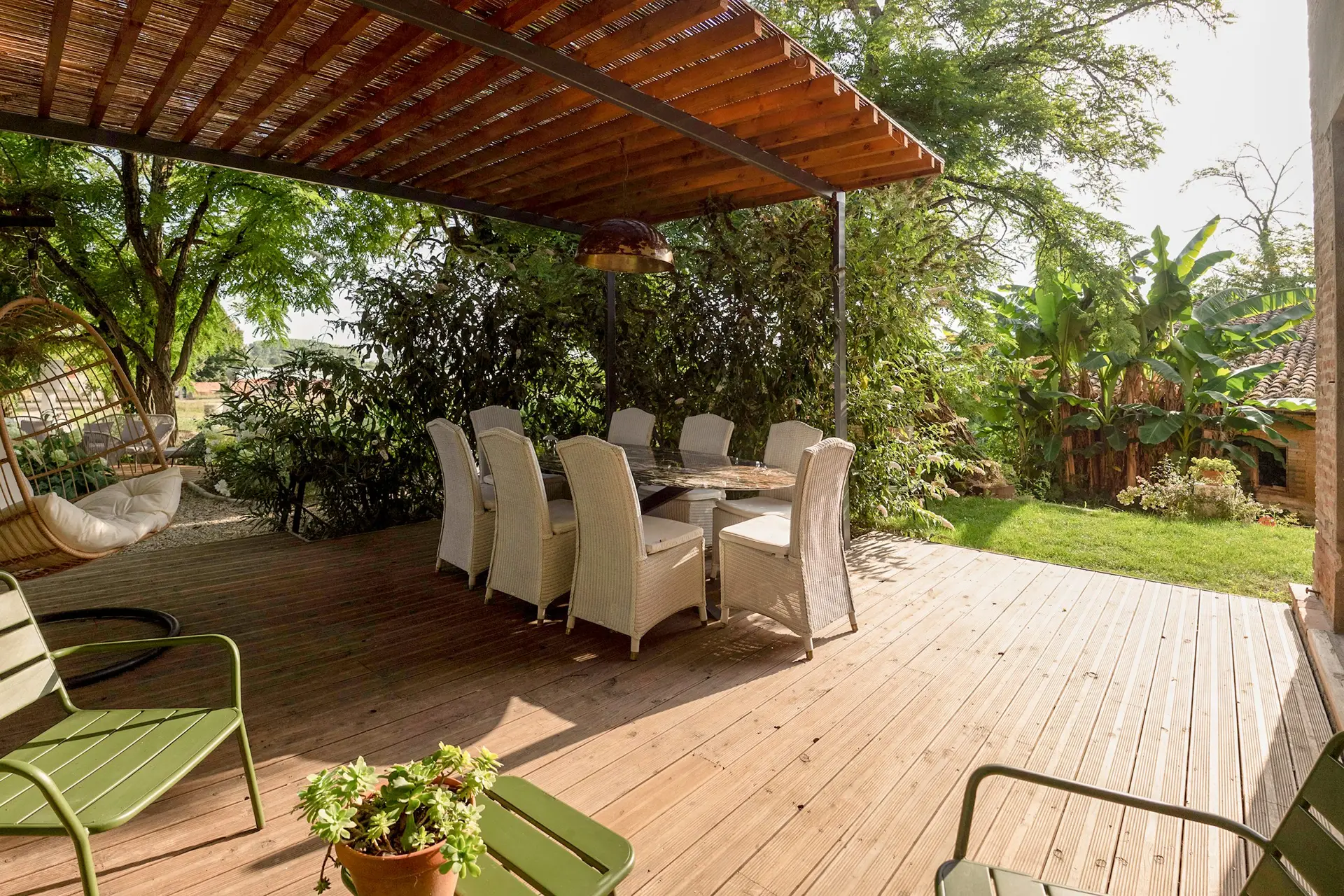 Cap de Rivière : terrasse couverte en bois avec table à manger dans le jardin