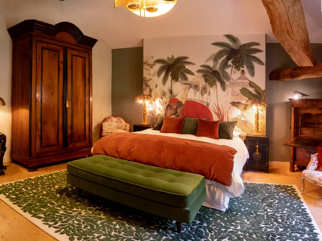 Cap de Rivière : chambre avec papier peint tropical et armoire ancienne