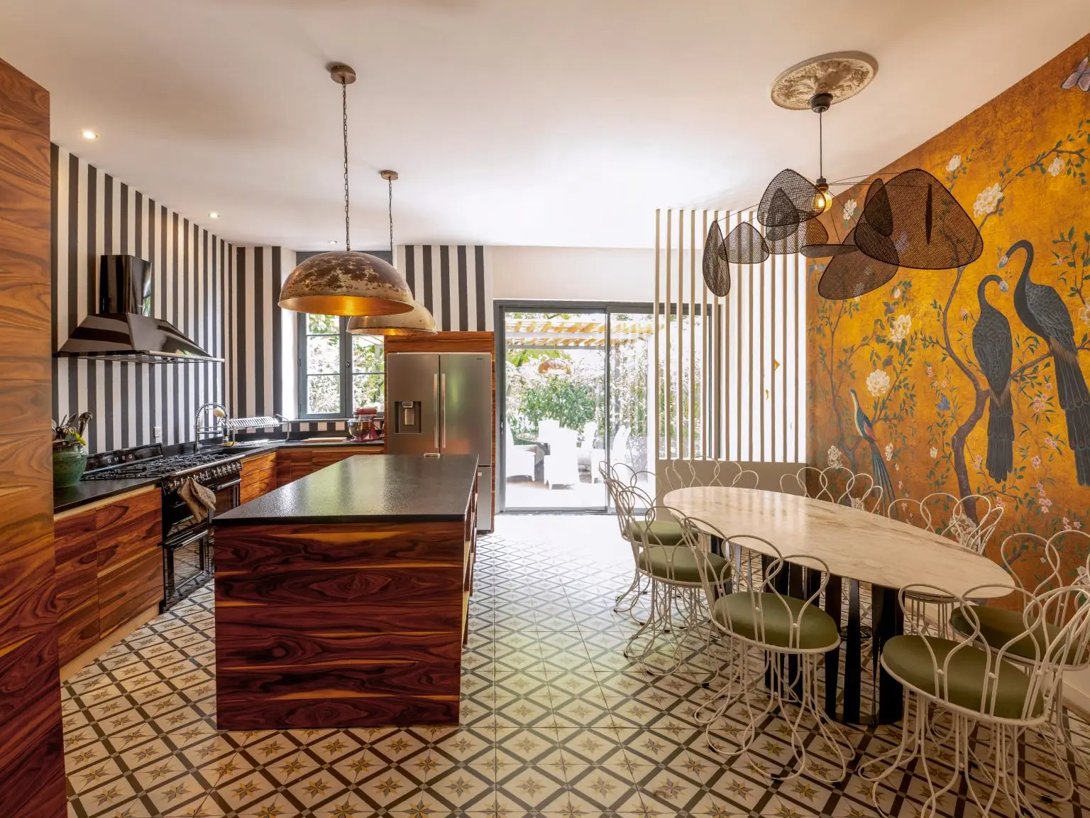 Cap de Rivière : cuisine avec îlot et salle à manger, fresque murale aux paons