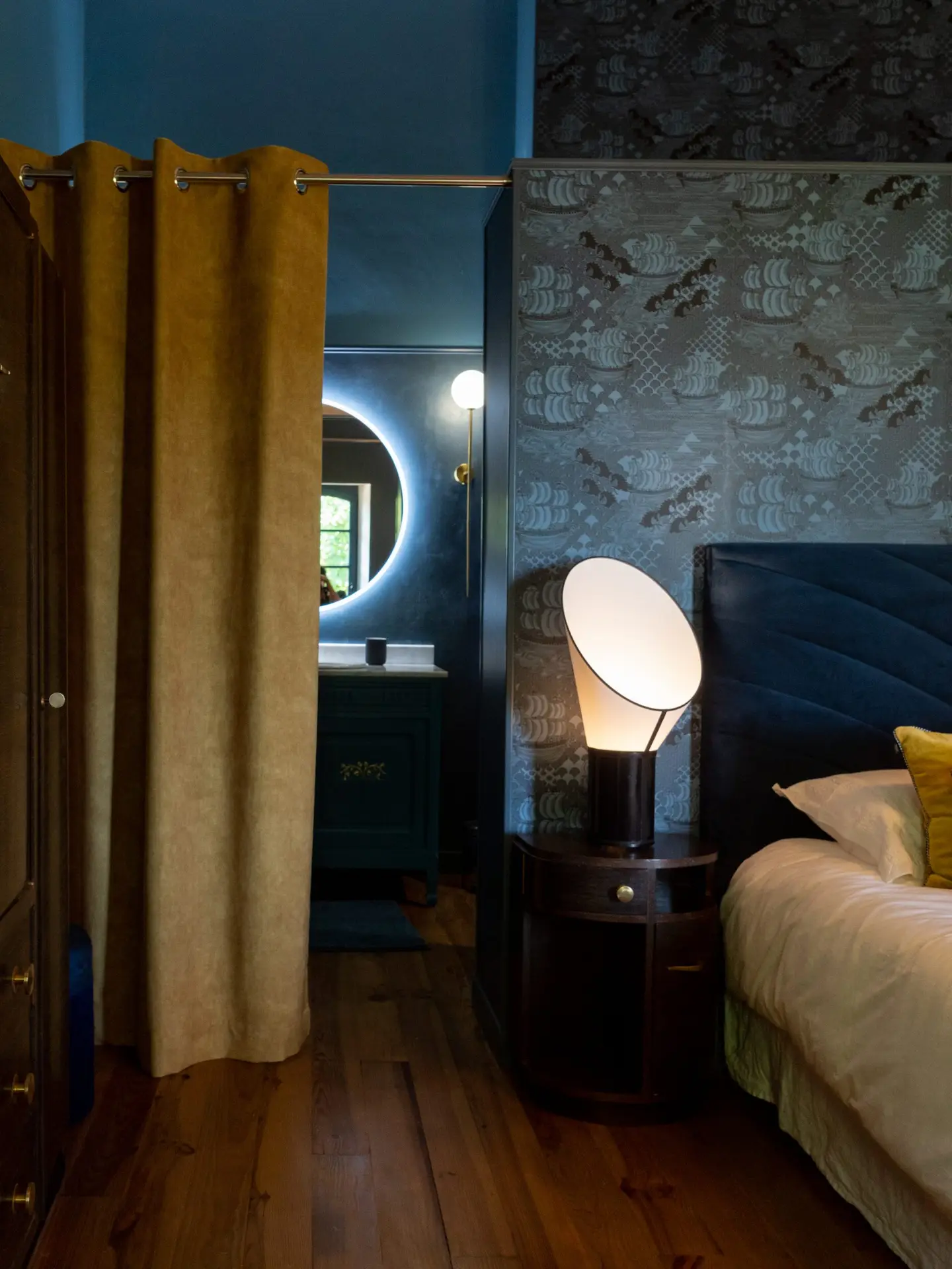 Chambre avec papier peint, rideaux en velours et lampe de chevet