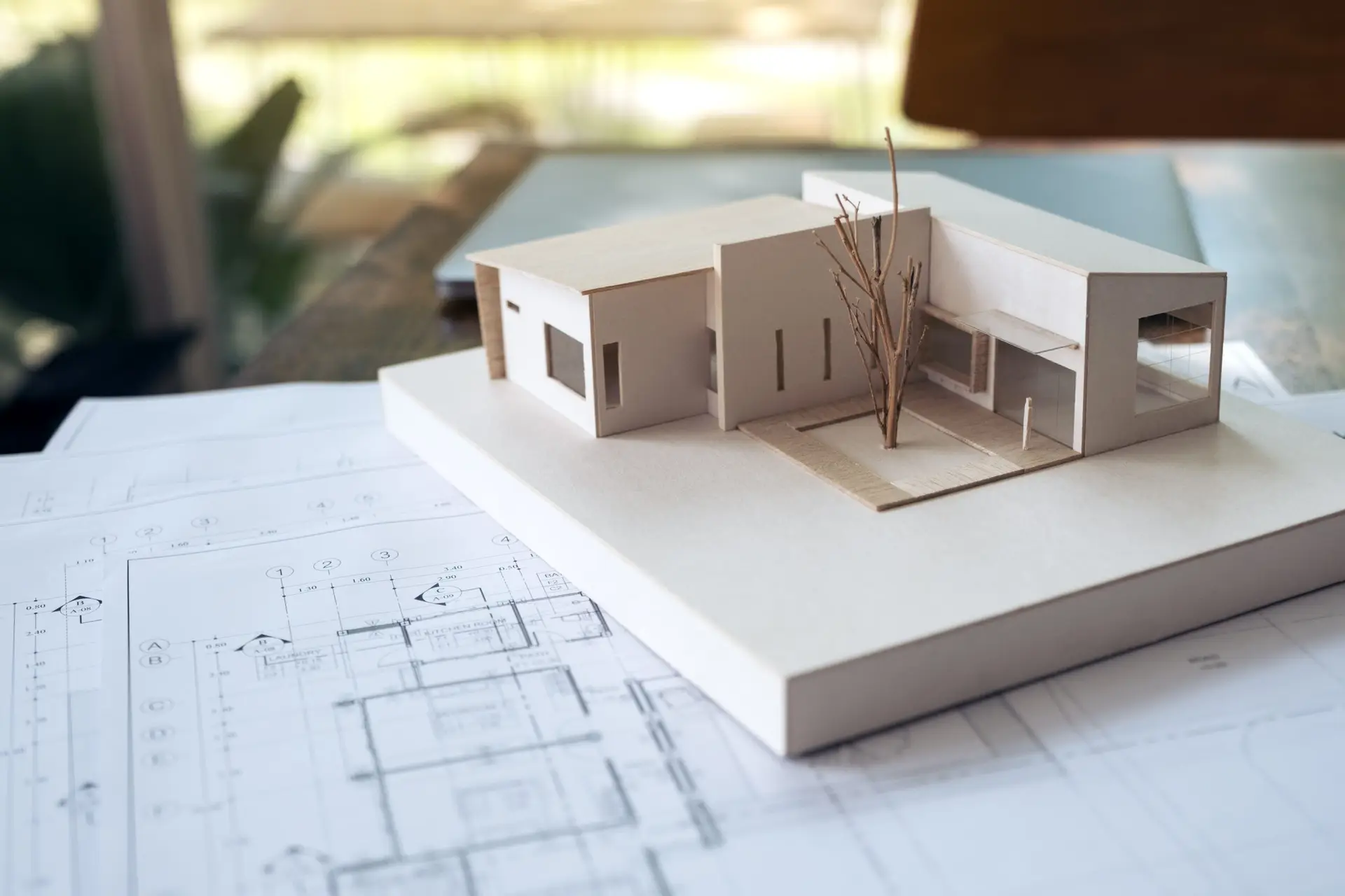 Maquette de maison pos&eacute;e sur des plans d&rsquo;architecture